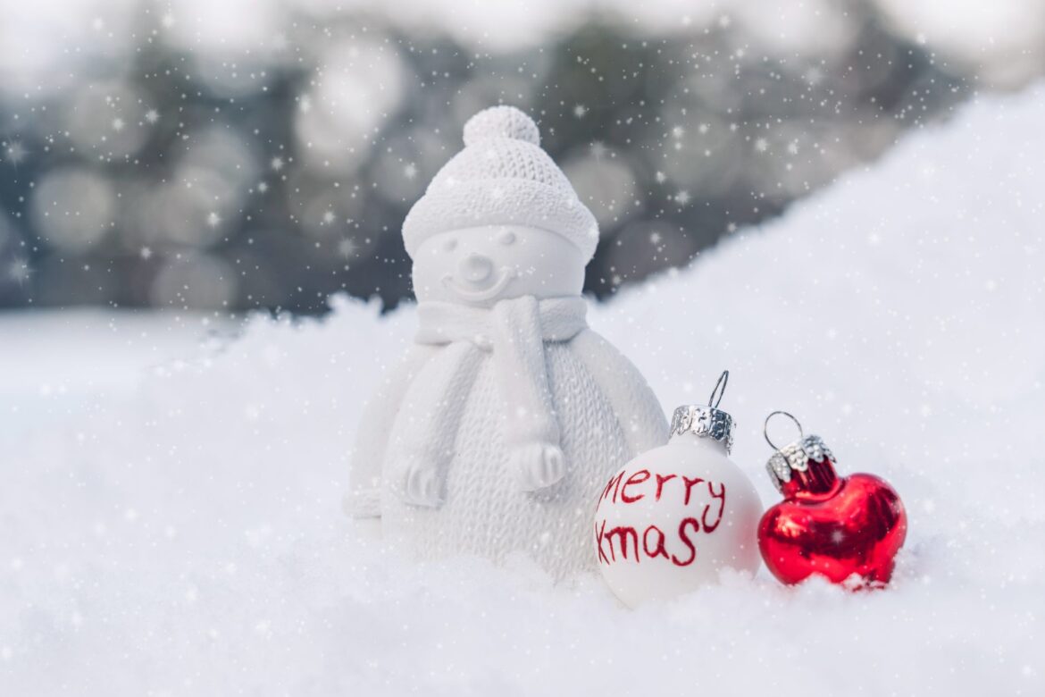 A charming snowman with Christmas ornaments in a snowy outdoor scene, perfect for holiday themes.