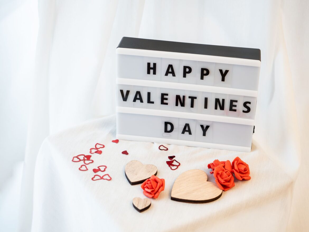 Romantic Valentine's Day setup with hearts and roses on a white background.