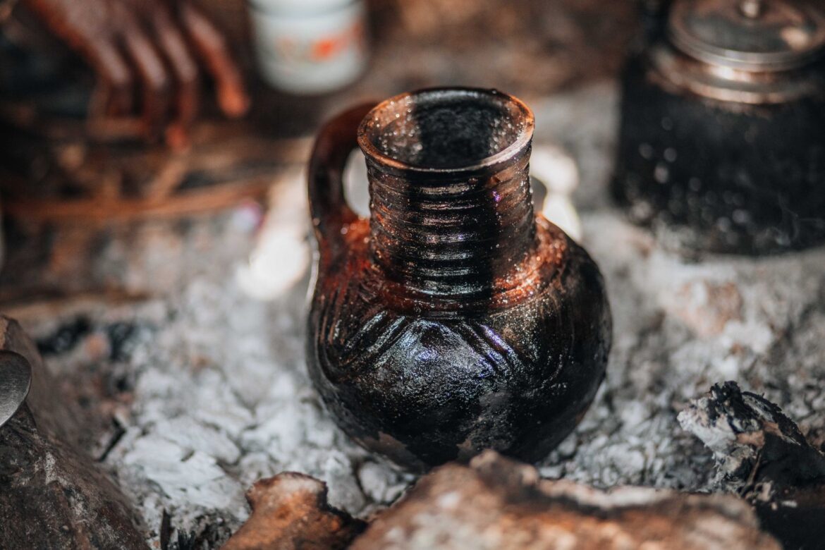 Close-up of a traditional Ethiopian stoneware pot among ashes, highlighting cultural craftsmanship.