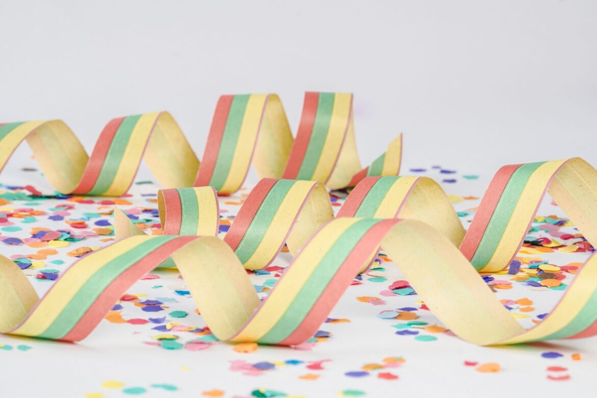 Vibrant paper streamers and confetti on a white background, perfect for festive occasions.
