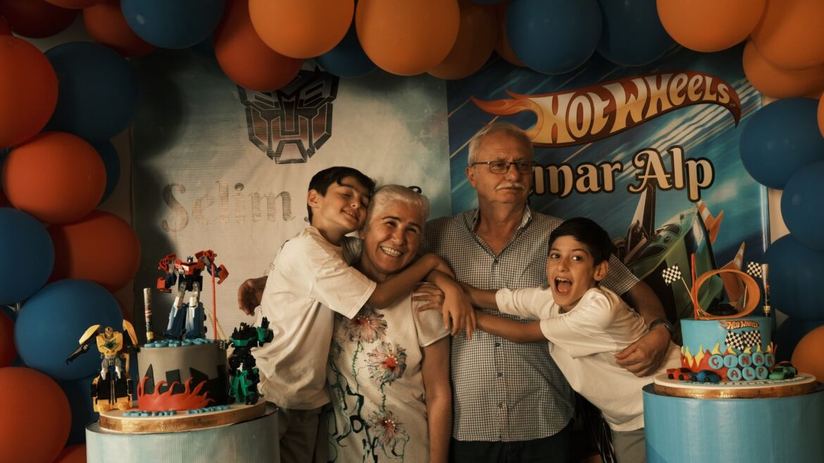 A joyful family celebrates a birthday with a themed party setup and cake.