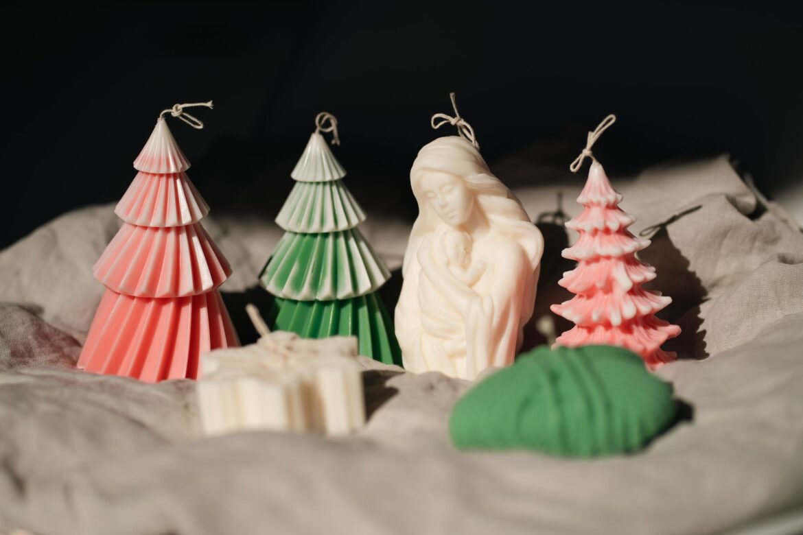 Colorful candles shaped as Christmas trees and a nativity scene create festive decor.
