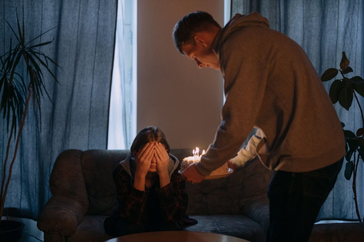 A surprise birthday moment captured indoors with candles and joyful anticipation.