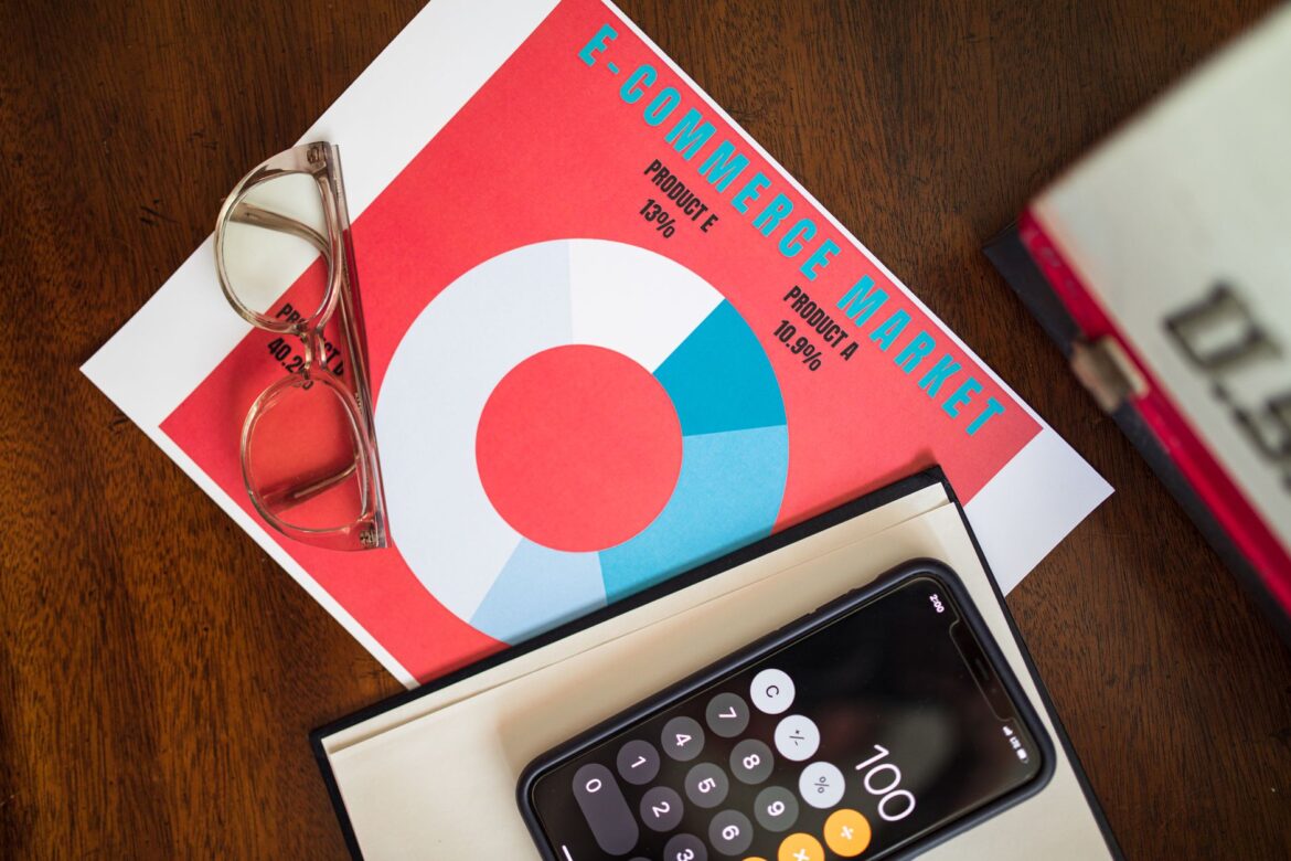 Top view of e-commerce market analysis graph with smartphone calculator and glasses for business insights.