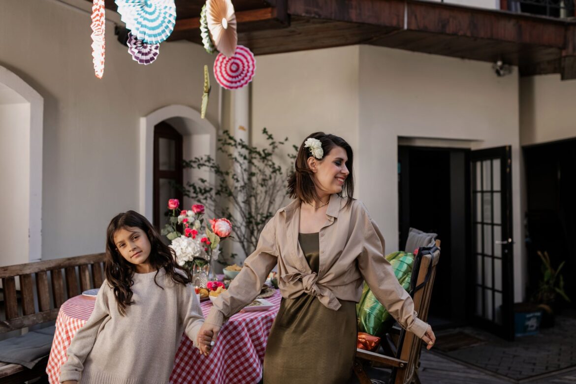 A cheerful mother and daughter celebrating indoors with decorations and a festive atmosphere.