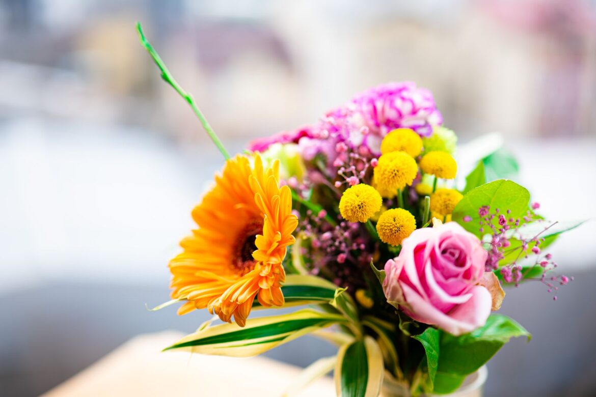 A colorful bouquet featuring a variety of spring flowers including gerbera, roses, and chrysanthemums.