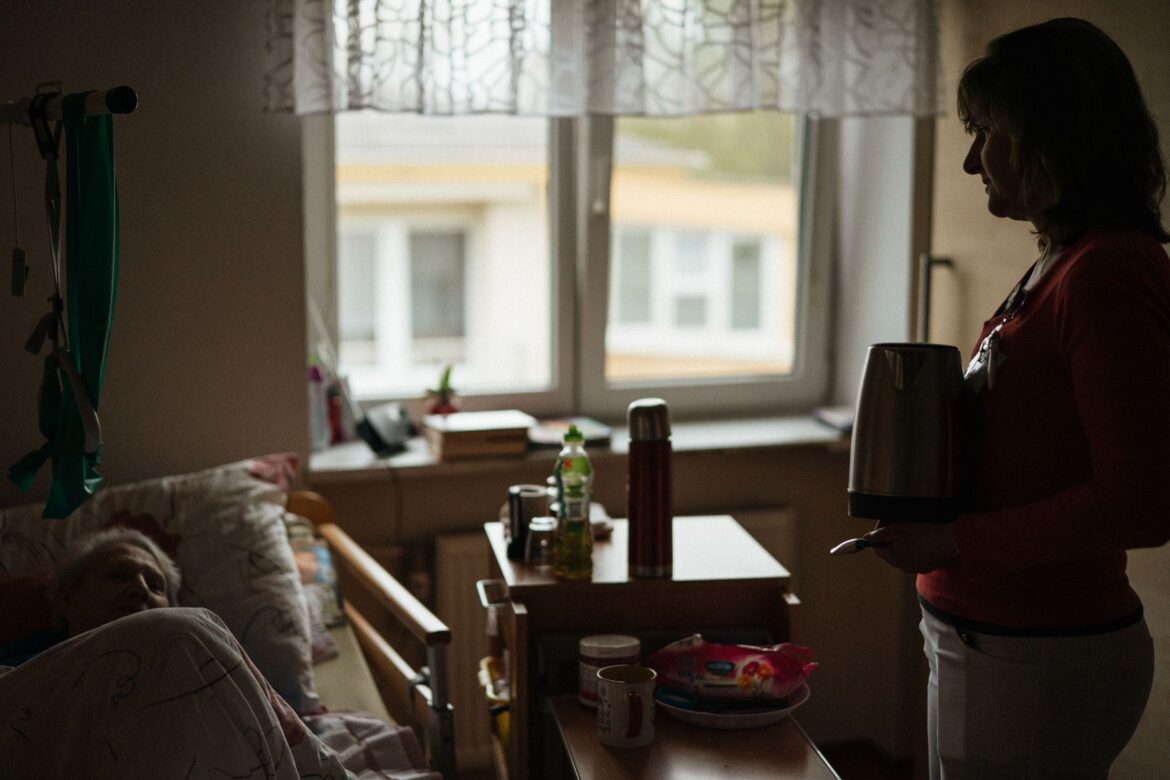 A caregiver prepares a warm drink for a senior in a peaceful retirement home setting.