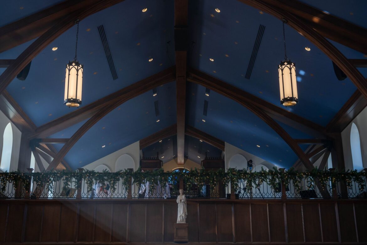 A beautifully decorated church interior in winter, featuring festive lights and garlands.