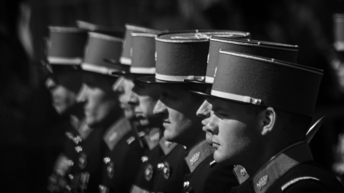 Black and white image of soldiers in uniform during a formal ceremony.