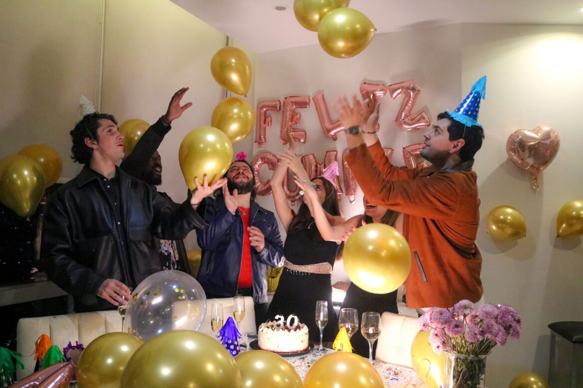 Vibrant birthday party with friends celebrating amidst balloons and festive decorations.