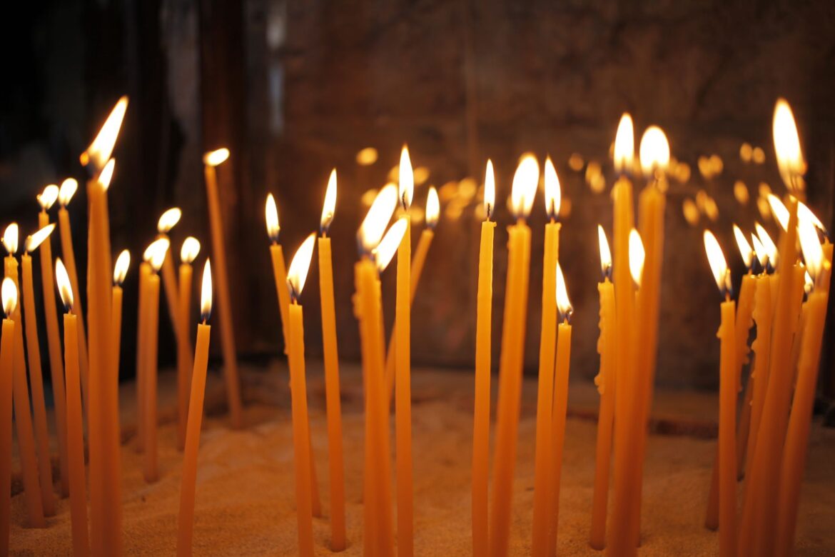 Warm and peaceful image of lit candles inside a church, symbolizing faith and reflection.