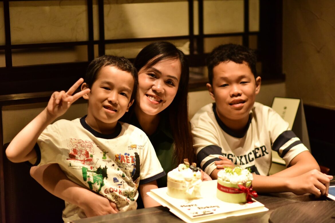 A joyful family celebration with children and a birthday cake indoors.
