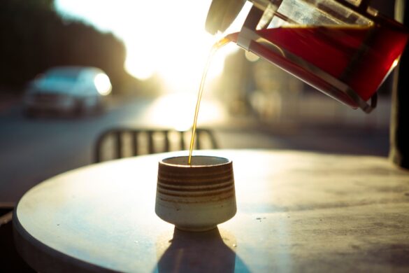 Warm morning light as coffee is poured into a cup at an outdoor cafe table in Baghdad.