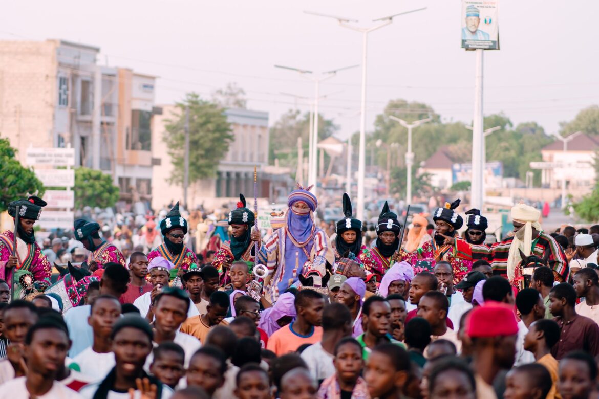 A lively street parade showcasing traditional attire and cultural festivities. Crowds gather to celebrate with vibrant colors.