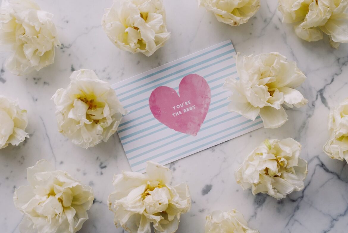 A heartfelt card with flowers on a marble surface conveys love and appreciation.