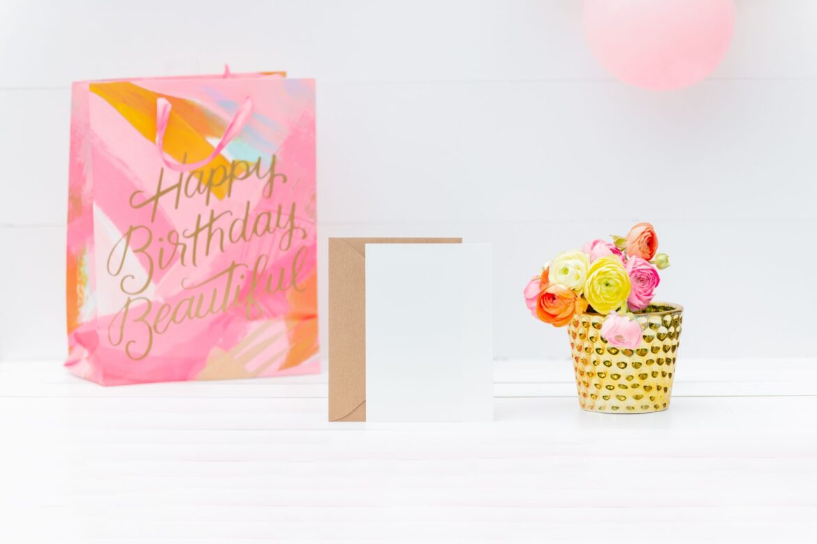 Bright and cheerful birthday setup with a gift bag, greeting card, and floral decoration.