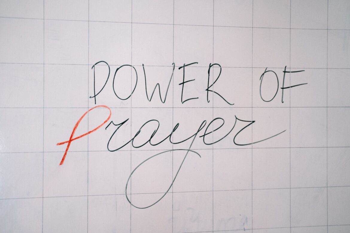 Handwritten 'Power of Prayer' message on a tiled surface conveying spirituality and inspiration.