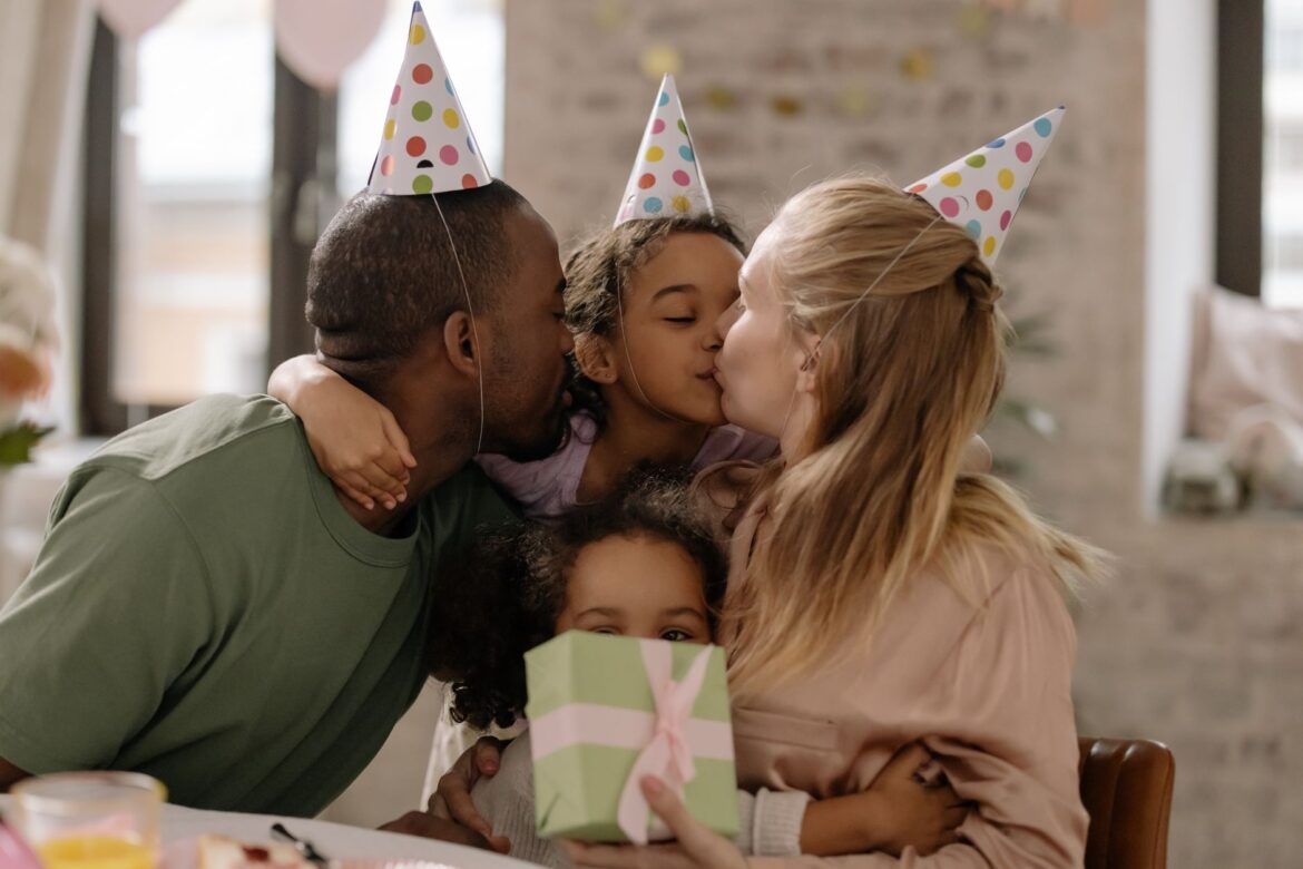 A joyful family celebration with parents and children enjoying a birthday party, complete with hugs and gift giving.