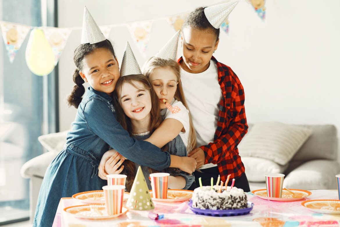 Group of kids enjoying a fun birthday party with cake and hats indoors.