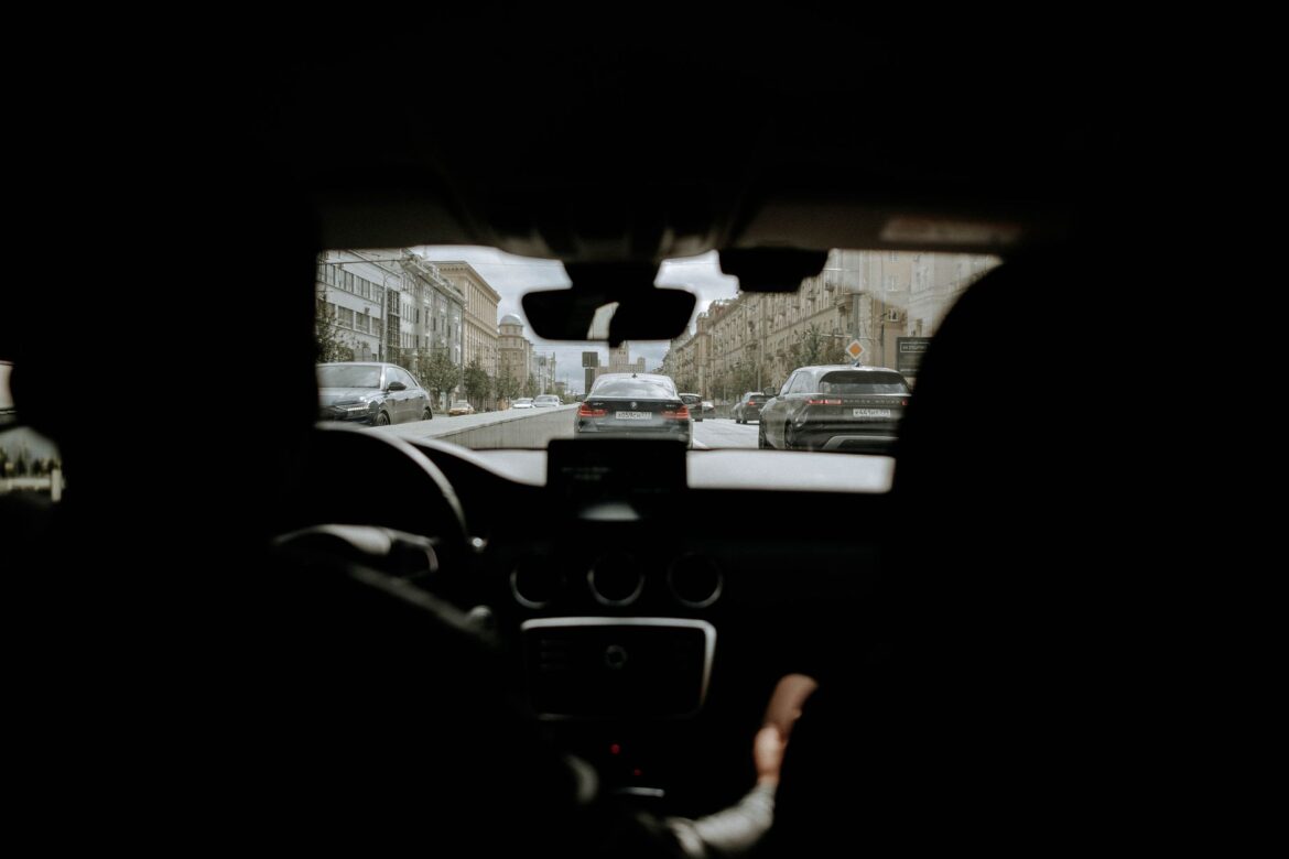 A cityscape view from inside a vehicle showcasing urban traffic and buildings.