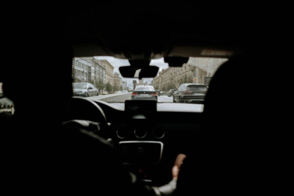 A cityscape view from inside a vehicle showcasing urban traffic and buildings.