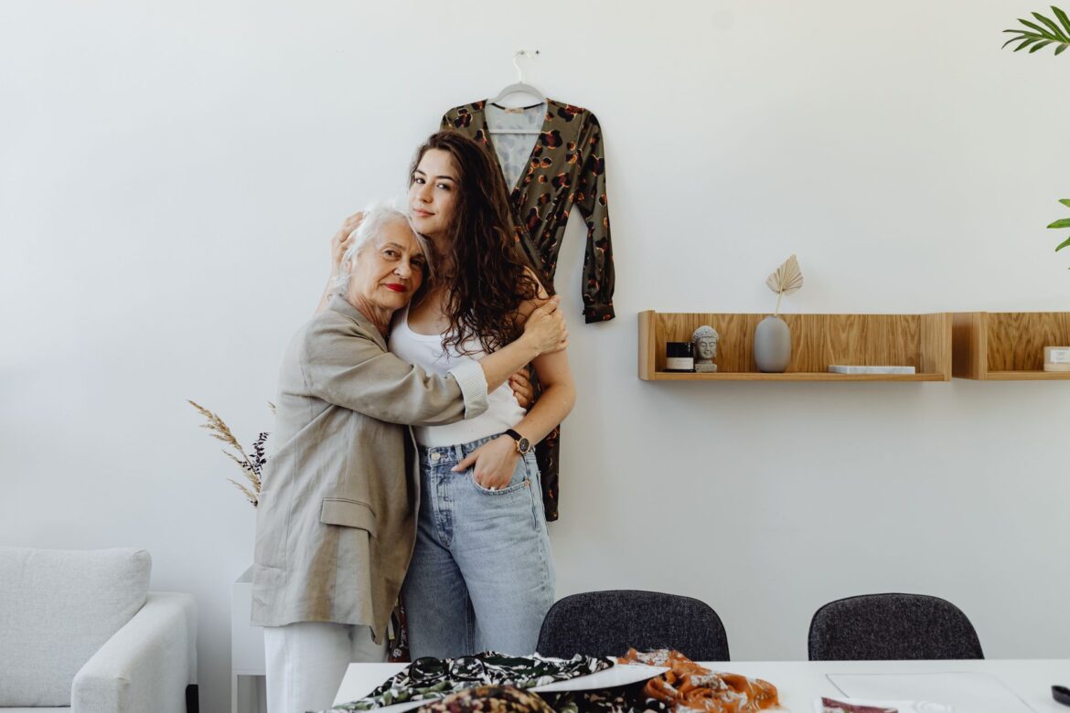 A grandmother and granddaughter share a tender hug in a cozy indoor setting, emphasizing family bonds.
