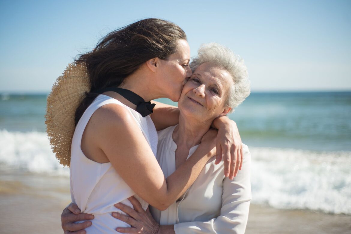 A touching moment of love as a mother and daughter embrace on a sunny beach.