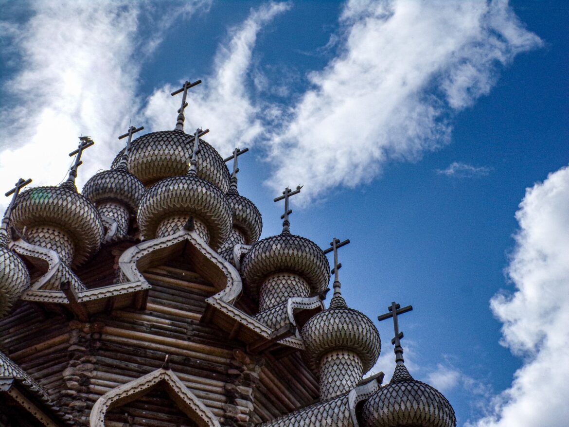 Low angle view of the Church of the Transfiguration domes on Kizhi Island under a blue sky.